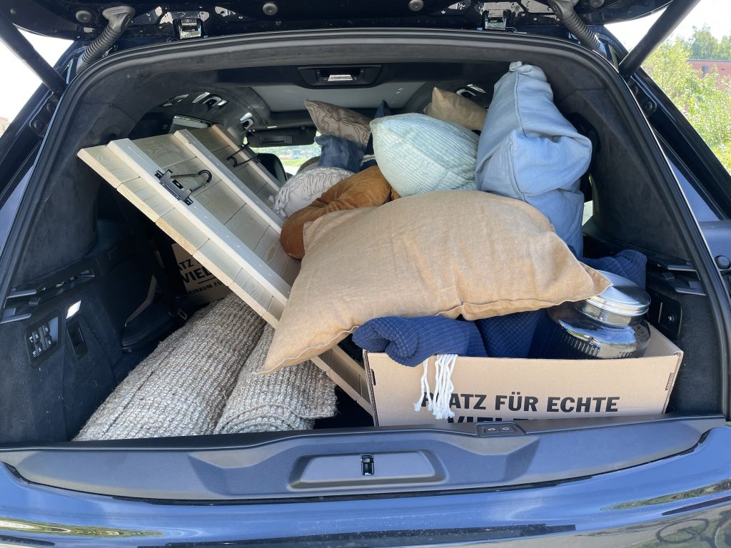 Voll beladener Kofferraum mit Kissen, Decken und Picknickausstattung aus der Anfangszeit